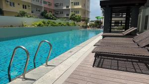 a swimming pool with benches next to some buildings at studio MA-DE cozy Bacolod City in Bacolod