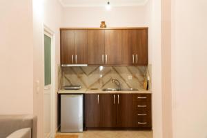 a kitchen with wooden cabinets and a sink at Joy & Grace Apartments Ksamil in Ksamil