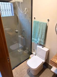 a bathroom with a toilet and a glass shower at Studio Central IV in Cascavel
