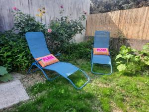 two chairs sitting in the grass in a yard at Le Gite Boho in Vendeuvre-du-Poitou