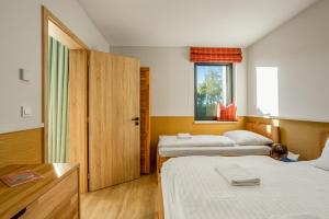 a hotel room with two beds and a window at Residence Krušec in Abertamy