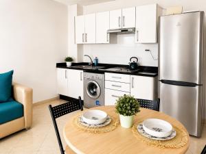 a kitchen with a table and a stainless steel refrigerator at Cozy Studio Near Beach with Pool Access in Martil