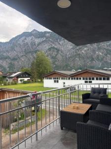 a balcony with chairs and a table and mountains at SC Apartments Bad Goisern - contactless check in in Bad Goisern