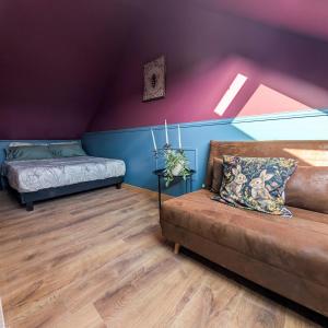 a living room with a couch and a bed at Le Boudoir d'Héloïse in Breux Jouy