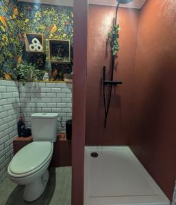 a bathroom with a toilet and a painting on the wall at Le Boudoir d'Héloïse in Breux Jouy