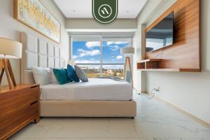 a bedroom with a bed and a large window at New 2BR APT - Beach Access - Pool - GYM - Jacuzzi in Nuevo Vallarta +33 photos