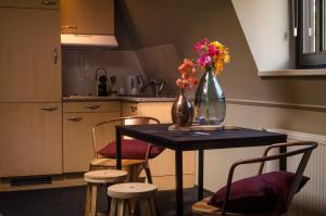 a kitchen with a table with a vase of flowers on it at Jambon in Uden