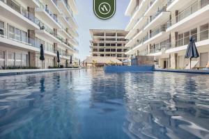 a swimming pool in the middle of a building at 3BR Condo Right Next to the Beach - Pool - Palapa in Nuevo Vallarta