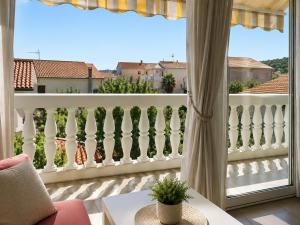a balcony with a white fence and a window at Apartments Marko in Vodice
