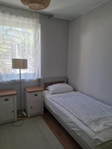 a bedroom with a bed and a lamp and a window at szemesd6 in Balatonszemes