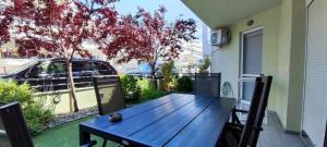 a porch with a wooden table and chairs on a balcony at Iliokalli Apartment in Nea Peramos +19 photos