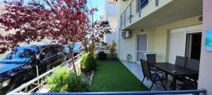 a small backyard with a table and a tree at Iliokalli Apartment in Nea Peramos
