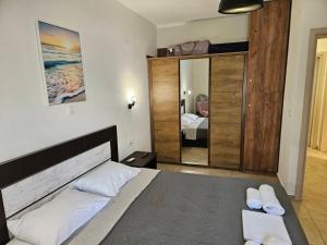 a bedroom with a bed and a large mirror at Iliokalli Apartment in Nea Peramos