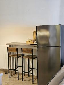 a kitchen with a table and a stainless steel refrigerator at Iliokalli Apartment in Nea Peramos
