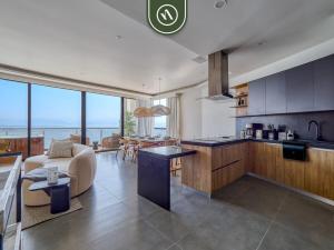 a kitchen and living room with a view of the ocean at Luxury Oceanfront 3 BR Condo with Balcony in Cruz de Huanacaxtle
