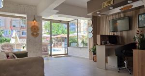 a living room with a couch and a tv at Palmen Apart Hotel in Alanya