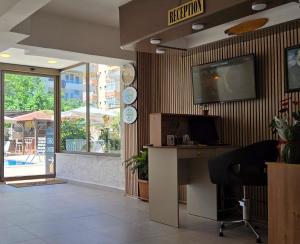 an office with a desk and a television on the wall at Palmen Apart Hotel in Alanya +194 photos