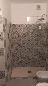 a bathroom with a toilet and a tiled wall at affittacamere de al vecchio scalo in Isola del Cantone