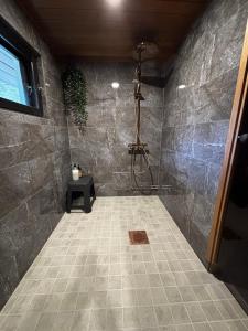 a bathroom with a shower with a stone wall at Villa Jalaja in Mäntyharju +26 photos