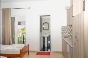 a bathroom with a bed and a sink in a room at Joy & Grace Apartments Ksamil in Ksamil