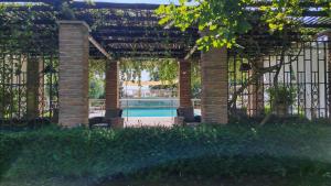 a pergola with two chairs and a swimming pool at B&B Casazze Dream in Marcaria