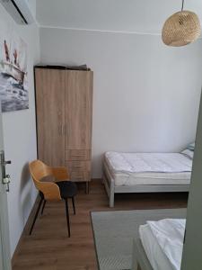 a bedroom with a bed and a chair and a cabinet at szemesd6 in Balatonszemes