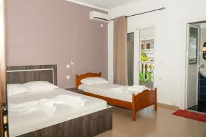 a bedroom with two beds with towels on them at Joy & Grace Apartments Ksamil in Ksamil