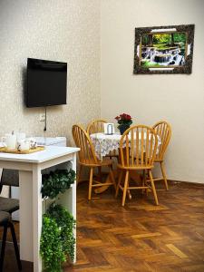 a dining room with a table and chairs and a tv at Gallery inn in Kutaisi