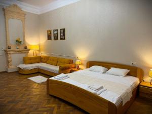 a bedroom with a large bed and a couch at Gallery inn in Kutaisi