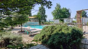 a swimming pool with a bench in a garden at B&B Casazze Dream in Marcaria +44 photos