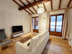 a living room with a white couch and a television at Bonlogem - Air-conditioned apartment Sainte Claire in Pertuis