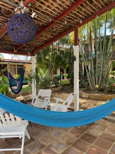 a hammock on a patio with chairs and palm trees at Hostal Harvest House in León