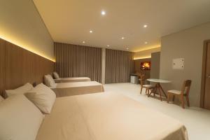 a hotel room with two beds and a table at Mantra Hotel in Feliz Natal