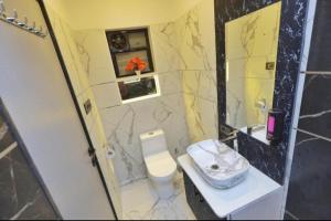 a bathroom with a toilet and a sink and a mirror at Velora Stays - Nr Airport & World trade center in Pune