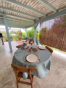 a table with plates on it on a patio at Charmant Bungalow Independant in Grand-Bourg +14 photos