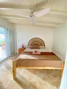 a bedroom with a bed and a ceiling fan at Charmant Bungalow Independant in Grand-Bourg