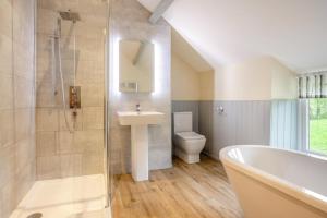 a bathroom with a tub and a sink and a toilet at 2 Bed in Abergele oc-88974 in Llanfair Talhaiarn +16 photos