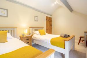 two beds in a room with yellow and white at 2 Bed in Abergele oc-88974 in Llanfair Talhaiarn