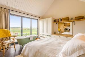 a bedroom with a tub and a bed and a window at 1 Bed in Wickhambrook oc-tosh in Wickhambrook