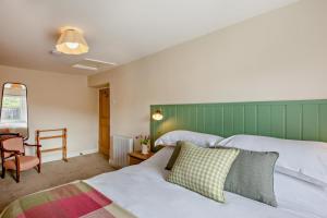 a bedroom with two beds and a chair at 3 Bed in Morpeth oc-75083 in Harbottle
