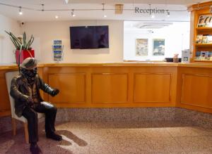 a statue of a man sitting in a waiting room at Grunau Hotel in Bayreuth
