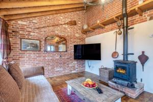 a living room with a brick wall and a stove at 6 Bed in Wangford oc-e31107 in Wangford