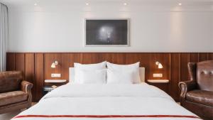 a hotel room with a bed and two chairs at Ruby Sofie Hotel Vienna by IHG in Vienna