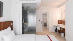 a bedroom with a white bed and a bathroom at Ruby Sofie Hotel Vienna by IHG in Vienna +71 photos