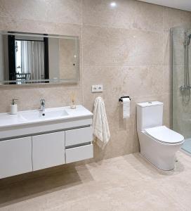 a bathroom with a sink and a toilet and a mirror at Apartamento Coworking in Novo Sancti Petri