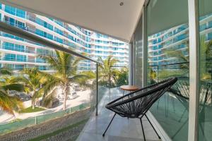 a chair on a balcony with a view of a city at Beachfront Duplex with Multiple Pools - Beachclub in Nuevo Vallarta