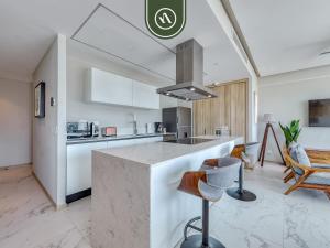 a kitchen with a counter and chairs in a room at Luxury 3 BR Condo - Beach Access 1 Block Away in Bucerías