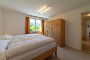 a bedroom with a large bed and a window at Churfirstenblick in Wildhaus