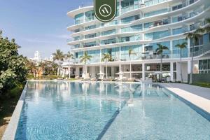 a swimming pool in front of a large building at Luxury 3 BR Condo - Beach Access 1 Block Away in Bucerías