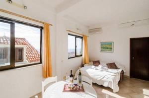 ドゥブロヴニクにあるApartment Butijerのベッドとテーブルと窓のある部屋